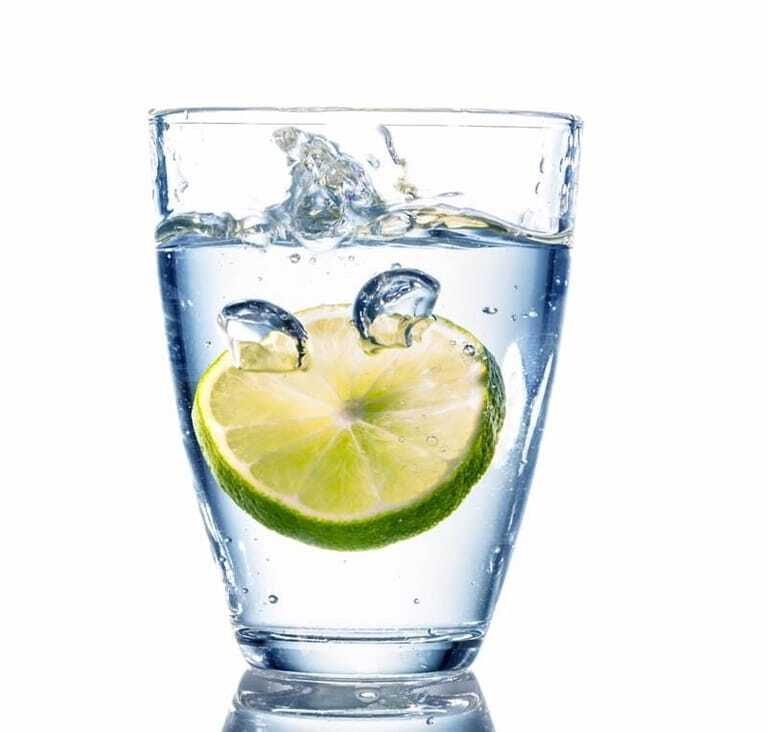 Glas Wasser mit einer Scheibe Limette.