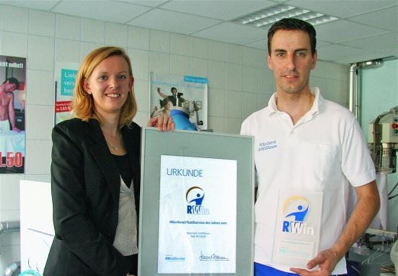 Steffen Schildhauer freute sich über den Branchenaward RWin 2011, den er von Elena Schönhaar, leitende Redakteurin von RWTextilservice, überreicht bekam. Foto: rwt