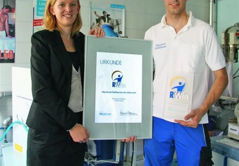 Steffen Schildhauer freute sich über den Branchenaward RWin 2011, den er von Elena Schönhaar, leitende Redakteurin von RWTextilservice, überreicht bekam. Foto: rwt