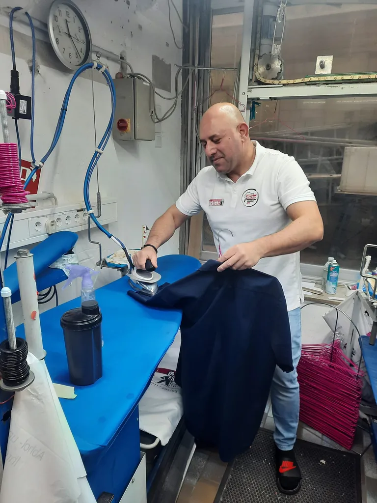 Mitarbeiter Sajjad Abdul-Slam an einem der Bügeltische im Untergeschoss.