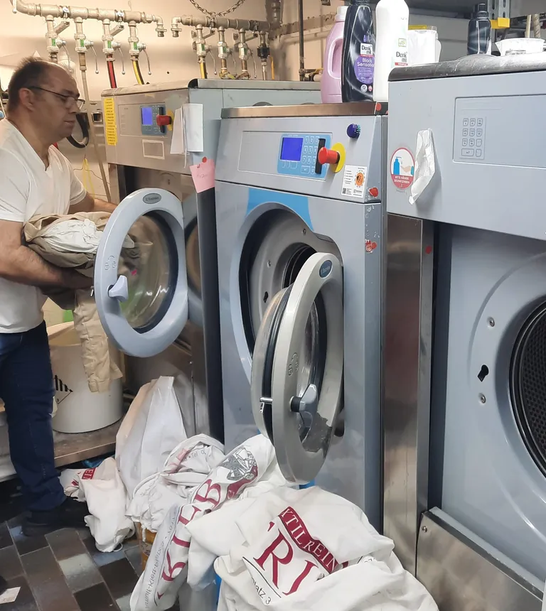 Mitarbeiter Miljazim Krasnic beim Befüllen der Waschmaschinen.