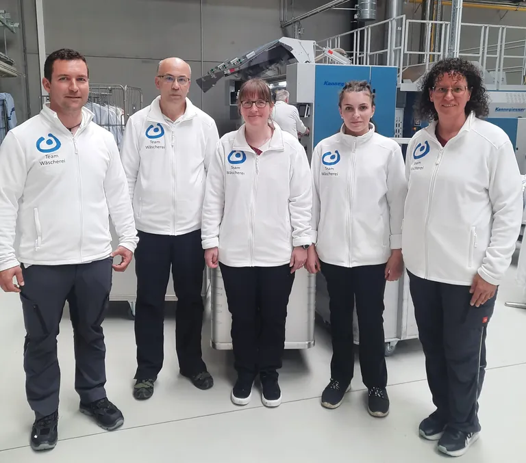 Gruppenfoto von Textilreinigermeister Fabian Fuchs und einigen seiner Kolleginnen und Kollegen.