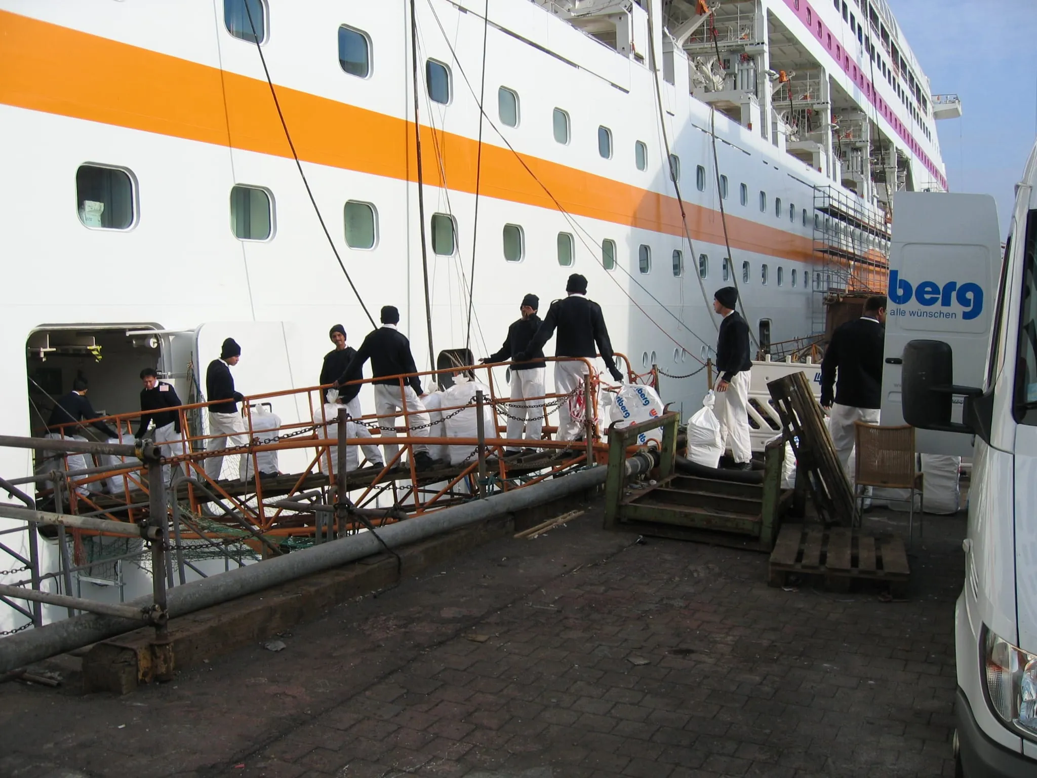 Wäschekreislauf mit Matrosen-Menschenkette. "Durch unseren eigenen Lieferservice sind wir in der Lage, Schiffswäsche innerhalb kürzester Zeit abzuholen, zu bearbeiten und termingenau wieder auszuliefern" so die Wäscherei Wartberg in Bremen.