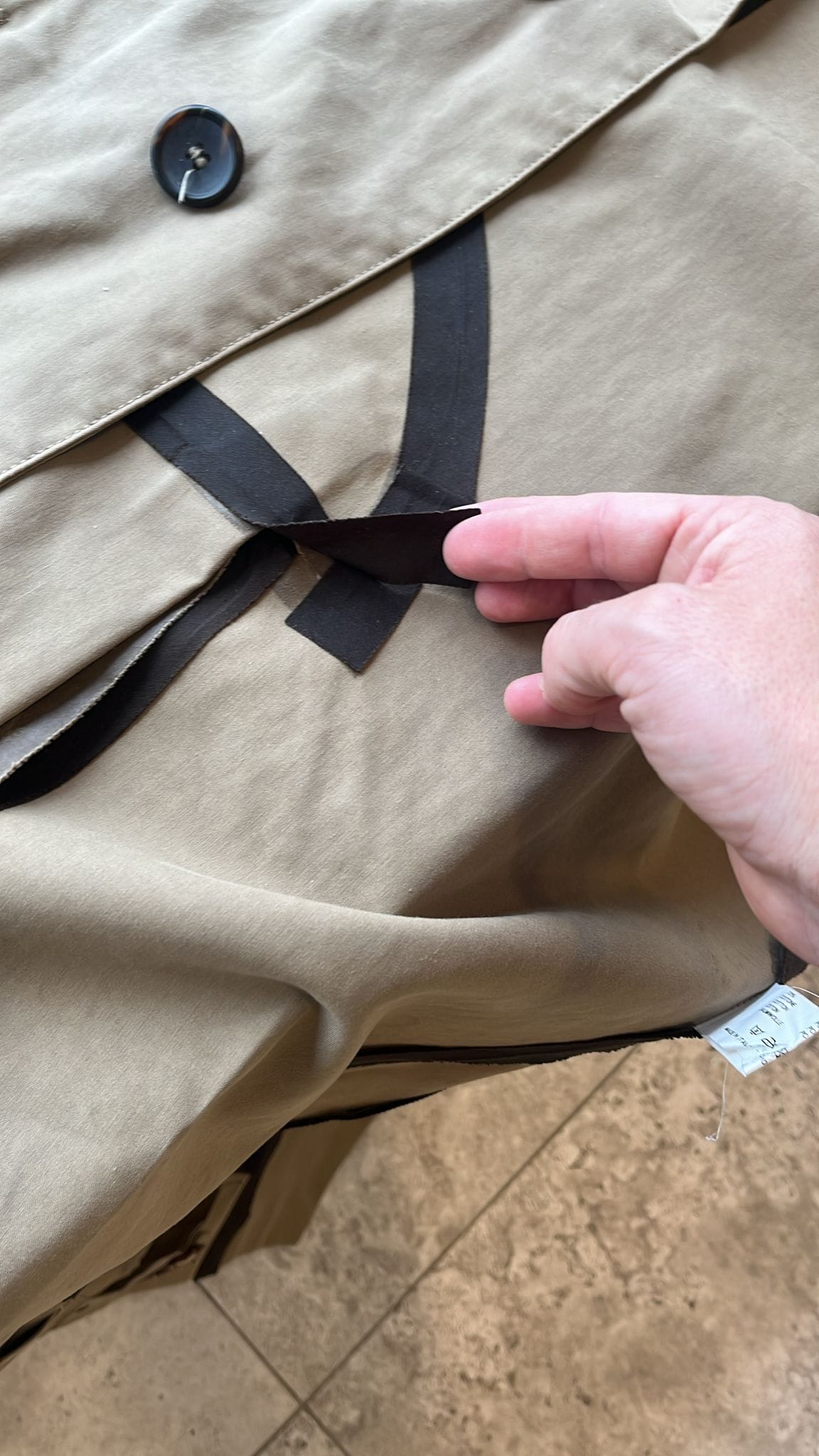 Der Regenmantel hat schwarze Streifen als optische Elemente.