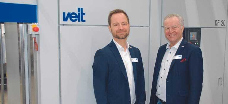 Günter und Christopher Veit, die beiden Geschäftsführer der VEIT GmbH, vor dem Kompaktfinisher CF 20, der sich gerade auch zum automatisierten Finishen von geringeren Stückzahlen eignet.