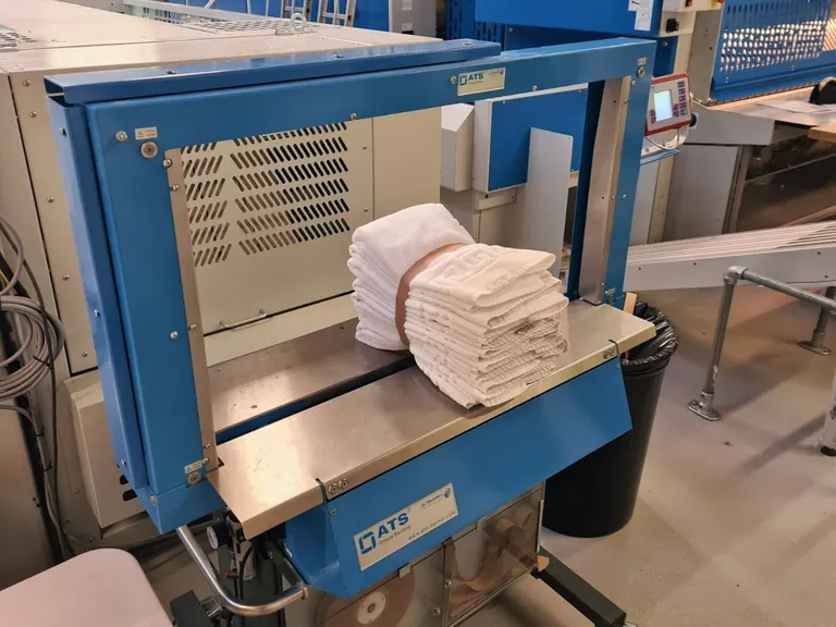 Mit Banderolen verpackte Textilien, wie der Handtuchstapel im Bild, lassen Restfeuchte entweichen.