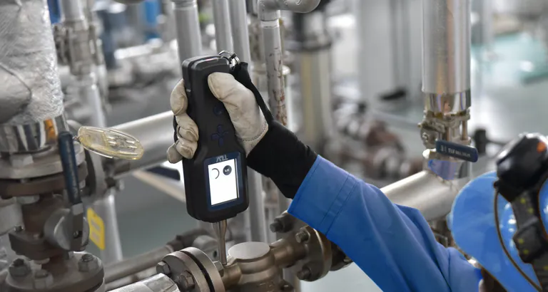 Mann prüft Kondensatableiter von Dampfleitungen.