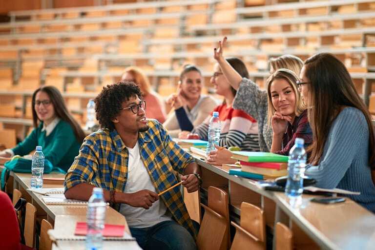Diverse Gruppe von Studenten, die in einem Hörsaal sitzen.
