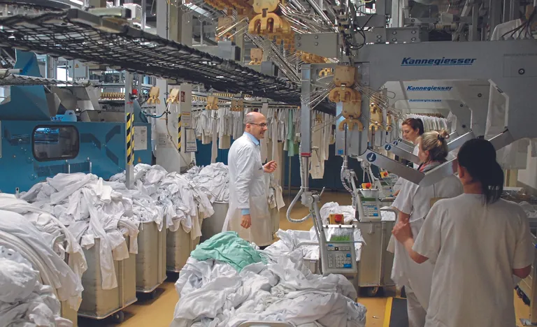 Samuel Bigot, Leiter der W&auml;scherei an der Uniklinik Freiburg, beim Gespr&auml;ch mit Mitarbeiterinnen in der Produktion. 