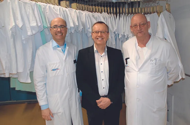 Freuen sich &uuml;ber ein gelungenes Projekt der Ressourceneinsparung an der W&auml;scherei der Uniklinik Freiburg (v.&thinsp;l.): Samuel Bigot (Leiter der W&auml;scherei), Beratungsexperte Dipl.-Ing. Wilhelm Bringewatt und Thomas Rotzler (Produktionsleiter). 