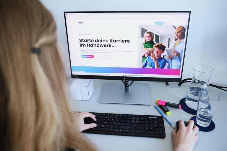 Junges Mädchen sitzt am Schreibtisch vor einem PC und hat die Website "130 Chancen" der Handwerkskammer Region Stuttgart geöffnet.