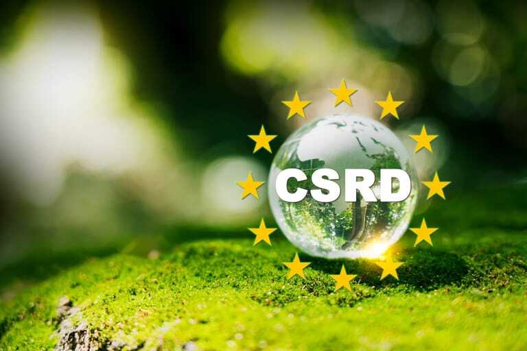 Transparente Glaskugel mit der Aufschrift "CSRD" auf moosbedecktem Untergrund, umgeben von zw&ouml;lf gelben Sternen in Kreisform &ndash; Symbolbild f&uuml;r Nachhaltigkeit und Transparenz im Rahmen der EU-Richtlinie. Im Hintergrund eine gr&uuml;ne, unscharfe Naturkulisse.