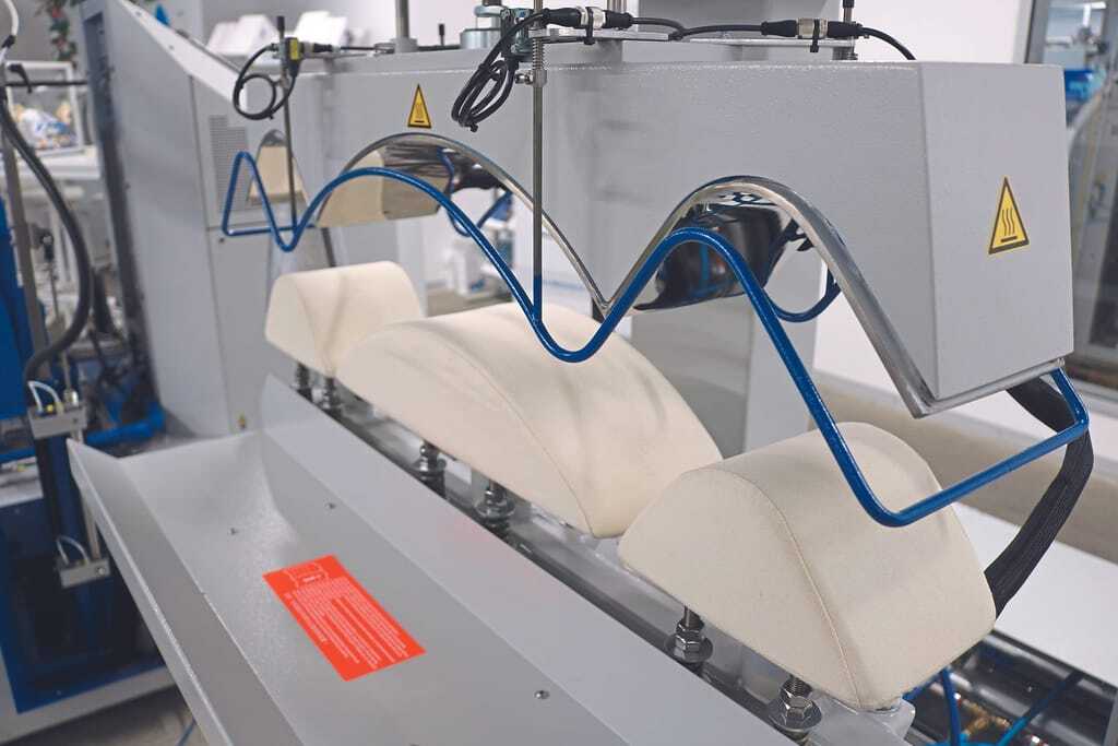 Die „Veit 8905“ Dreikopfpresse trocknet und finisht Kragen und Manschetten.