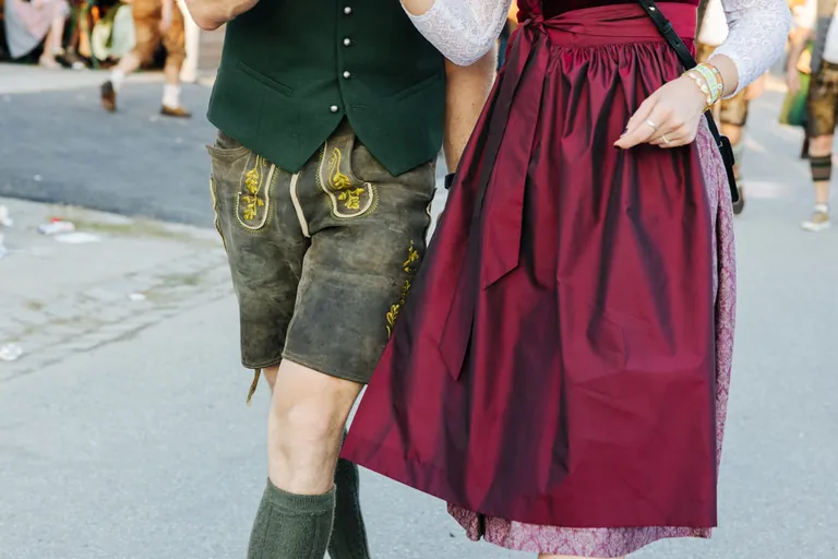 Wie bleiben Dirndl und Lederhose schön. Mann und Frau tragen traditionelle Tracht.