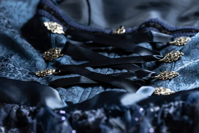 Nahaufnahme eines blauen Dirndl mit seinen Zierhaken und Schüren.
