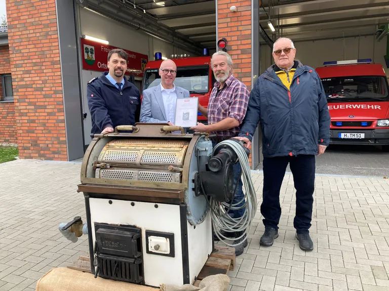 Die Ortsfeuerwehr Burgdorf-Schillerslage besitzt die &auml;lteste betriebsbereite Gewerbewaschmaschine in Deutschland: (v.li.): Ortsbrandmeister Timo Scheffler, Michael Arendes, Marketingmanager Miele, Heiner Wehrs, erster Vorsitzender des F&ouml;rdervereins und &bdquo;Restaurator&ldquo; Wolfgang Heldt. 