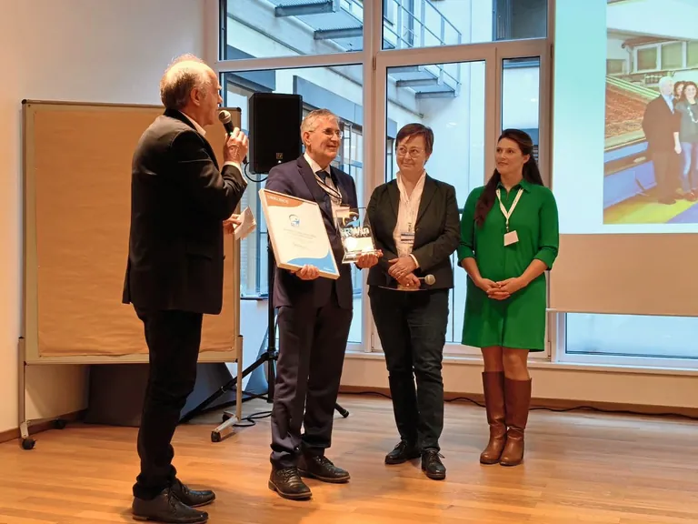 Den RWin &uuml;berreichte Peter Schmid (v.&thinsp;li.) an Franz Lang. F&uuml;r die RWin-Jury sprach BIM Andrea Kuttner. Gabriela &shy;Steiner w&uuml;rdigte als ehemalige &shy;Sch&uuml;lerin und Kollegin sein Engagement in einem Bildervortrag.