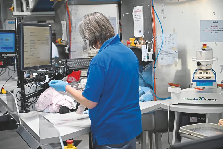 Die Bewohnerw&auml;sche wird an einem Sortierstand kontrolliert, bei Bedarf mit einem Barcode-Label versehen, eingescannt und von einem F&ouml;rderband bis zum festgelegten Bearbeitungsschacht transportiert.