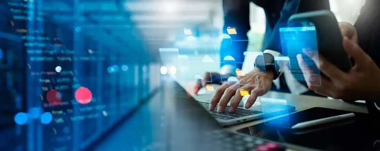 Zwei Personen programmieren etwas am Laptop und am Smartphone.
