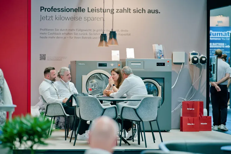 Mitarbeiter der Firma Miele sitzen auf der Clean Pro Expo in Friedrichshafen zusammen.